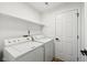 Functional laundry room equipped with modern washer and dryer units, as well as shelving at 7061 Woodgate Cir, Fishers, IN 46038