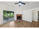 Bright living room featuring a fireplace, ceiling fan, and sliding doors to the screened in patio at 7061 Woodgate Cir, Fishers, IN 46038