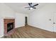 Bright living room featuring a brick fireplace, ceiling fan, and wood-look flooring at 7061 Woodgate Cir, Fishers, IN 46038