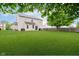 A view of a large backyard with lush green lawn and back exterior of the house at 73 Spring Lake Dr, Westfield, IN 46074
