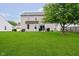 The backyard features a lush green lawn, and back exterior of the house at 73 Spring Lake Dr, Westfield, IN 46074