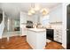 Open kitchen with island, white cabinets, and modern appliances leading into the living area at 73 Spring Lake Dr, Westfield, IN 46074