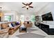Bright living room featuring two sofas, large windows, a ceiling fan, and a unique geometric rug at 73 Spring Lake Dr, Westfield, IN 46074