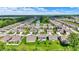 Aerial view of the community showcasing its layout, green spaces, and a scenic pond at 7319 Farlin Dr, Whitestown, IN 46075