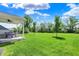 Manicured backyard with a covered patio and open green space and trees at 7319 Farlin Dr, Whitestown, IN 46075