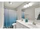 Bathroom with a double sink vanity, large mirror, and a shower with a blue and white curtain at 7319 Farlin Dr, Whitestown, IN 46075