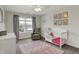 Bright bedroom featuring a large window, chair, crib, and charming decor, creating a cozy and inviting space at 7319 Farlin Dr, Whitestown, IN 46075