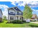 Charming home featuring blue siding, white trim, and a lush green lawn with a young tree at 7319 Farlin Dr, Whitestown, IN 46075