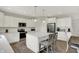 Bright kitchen features white cabinetry, stainless appliances, and a center island with seating for a modern touch at 7319 Farlin Dr, Whitestown, IN 46075