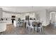 Kitchen and dining area featuring stainless appliances, white cabinetry, subway tile backsplash and wood-look flooring at 7319 Farlin Dr, Whitestown, IN 46075