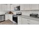 Close-up showcasing the stainless steel appliances, white subway tile backsplash, and light countertops in the kitchen at 7319 Farlin Dr, Whitestown, IN 46075