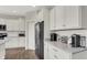 White kitchen with stainless steel appliances, granite countertops, and ample storage, perfect for culinary enthusiasts at 7319 Farlin Dr, Whitestown, IN 46075