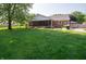 Spacious backyard features a lush green lawn, mature tree, patio, and a charming screened-in porch at 7450 Cotherstone Ct, Indianapolis, IN 46256