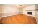 Spacious living room with hardwood flooring, a white brick fireplace, and built-in shelving at 7450 Cotherstone Ct, Indianapolis, IN 46256