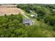 Captivating aerial view of the home and outbuilding surrounded by mature trees, a spacious lawn and farm fields at 8555 S County Road 375 E, Mooresville, IN 46158