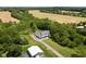 Expansive aerial view showcasing the home, mature trees, sprawling lawn and surrounding farmland at 8555 S County Road 375 E, Mooresville, IN 46158