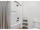 Clean bathroom with white subway tile, black fixtures, shower with curtain, and a storage shelf at 8555 S County Road 375 E, Mooresville, IN 46158