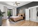 Comfortable bedroom features a dark accent wall, ceiling fan, and sliding glass doors to backyard at 8555 S County Road 375 E, Mooresville, IN 46158