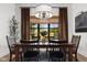 Charming dining room with a wooden table, dark chairs, and large windows offering a view of the greenery at 8555 S County Road 375 E, Mooresville, IN 46158