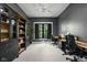 Home office features a large built-in cabinet, two desks, neutral carpet, and a window with black trim at 8555 S County Road 375 E, Mooresville, IN 46158