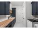 Well-lit laundry room features navy cabinets, a wood countertop, stylish flooring and modern appliances at 8555 S County Road 375 E, Mooresville, IN 46158