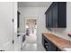 Functional laundry room with a washer, dryer, navy cabinets, butcher block countertop, and stylish tile floors at 8555 S County Road 375 E, Mooresville, IN 46158