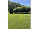 Lush green backyard featuring a well-maintained lawn, decorative hedges, and a charming garden trellis at 8655 Chateaugay Dr, Indianapolis, IN 46217