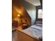Cozy bedroom featuring a rocking chair, crib, and comfortable bed beneath an angled ceiling at 8655 Chateaugay Dr, Indianapolis, IN 46217