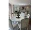 Bright dining area featuring a white table and chairs adjacent to a modern, well-equipped kitchen with white cabinets at 8655 Chateaugay Dr, Indianapolis, IN 46217