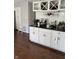 Charming kitchenette with white cabinets, black countertop, wine racks, and stylish backsplash, perfect for entertaining at 8655 Chateaugay Dr, Indianapolis, IN 46217