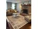 Inviting living room featuring a brick fireplace, hardwood floors, and stylish decor, creating a cozy atmosphere at 8655 Chateaugay Dr, Indianapolis, IN 46217