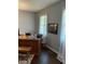 Office space featuring wood desk, hardwood floors, natural light from window with white curtains, and artwork on wall at 8655 Chateaugay Dr, Indianapolis, IN 46217