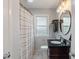 Updated bathroom with a dark vanity, round mirror, shower with curtain, and elegant light fixture at 895 W Poplar St, Zionsville, IN 46077