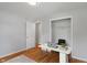 Staged bedroom featuring hardwood floors, closet and desk with laptop at 895 W Poplar St, Zionsville, IN 46077