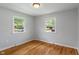Bright bedroom featuring hardwood floors, two windows, and neutral gray walls at 895 W Poplar St, Zionsville, IN 46077