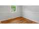 Small empty bedroom featuring hardwood floors, baseboard trim and a window with natural sunlight at 895 W Poplar St, Zionsville, IN 46077