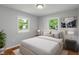 Well staged bedroom featuring hardwood floors, natural sunlight, bed, lamps and contemporary painting at 895 W Poplar St, Zionsville, IN 46077