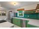 Kitchen with stainless steel appliances, green cabinets, and emerald green backsplash at 895 W Poplar St, Zionsville, IN 46077
