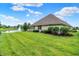 Backyard showcases a well-manicured lawn, a serene pond with a fountain, and lush landscaping at 896 Fairfield Dr, Greenfield, IN 46140