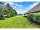 Expansive backyard featuring a pond with a fountain, lush landscaping, and mature trees creating a serene outdoor space at 896 Fairfield Dr, Greenfield, IN 46140