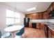 Eat-in kitchen with wood cabinets, black appliances, and round dining table with chairs at 9117 Thoreau Ct, Fishers, IN 46037
