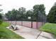 Outdoor tennis court with a fenced perimeter, landscaping, and a shaded bench at 9117 Thoreau Ct, Fishers, IN 46037