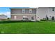 Large backyard with a well-maintained lawn, patio area, and a two-story brick and siding home at 9717 Chuckwalla Pl, Fishers, IN 46040