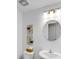 A half-bath with pedestal sink, round mirror, contemporary lighting and modern art at 9717 Chuckwalla Pl, Fishers, IN 46040