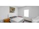 A simple bedroom with wood floors, artwork, and a bright window at 9717 Chuckwalla Pl, Fishers, IN 46040