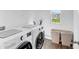 Bright laundry room featuring modern washer and dryer, storage cabinets, and a window with a view at 9717 Chuckwalla Pl, Fishers, IN 46040