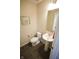Half bath includes a pedestal sink, toilet, artwork, and a wall mirror at 9903 Deep Royal Way, Indianapolis, IN 46239