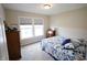 Cozy bedroom with a blue floral comforter, wooden dresser, and natural light at 9903 Deep Royal Way, Indianapolis, IN 46239