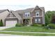 Inviting two-story home with a brick and siding facade, a lush green lawn, and mature trees at 9903 Deep Royal Way, Indianapolis, IN 46239