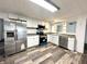 Modern kitchen featuring stainless steel appliances, white cabinetry, and durable wood-look floors for a stylish cooking space at 106 S Hancock St, Waynetown, IN 47990